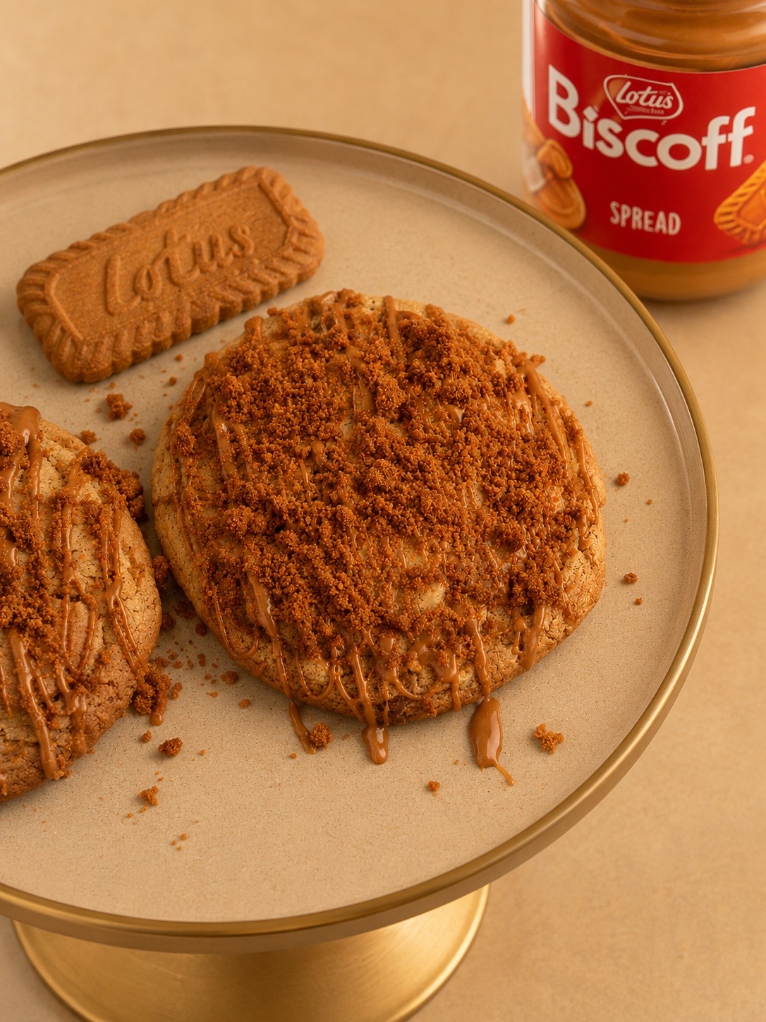 Biscoff cookies drizzled with Lotus Biscoff spread and crumble on a gold cake stand
